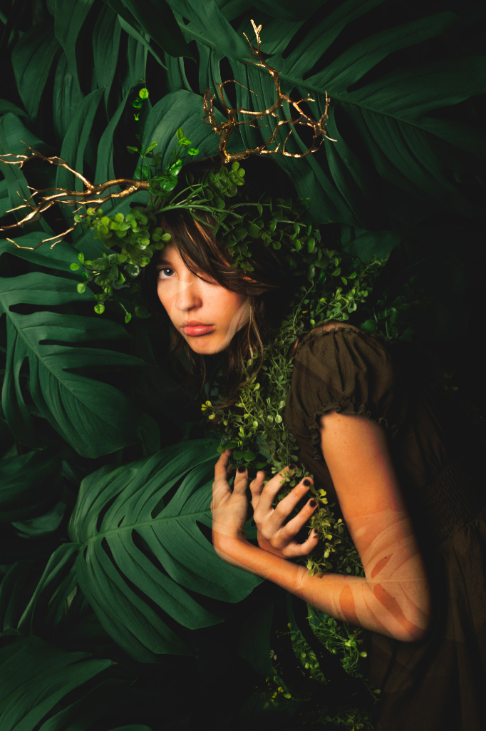 girl surrounded by big leaves