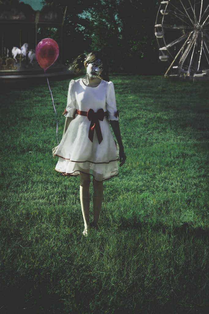 girl walking through carnival with balloon