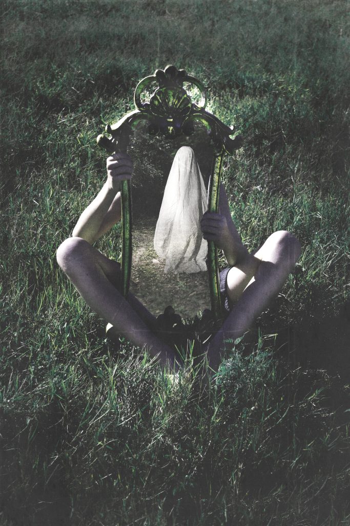 figure holding a mirror with ghost in it