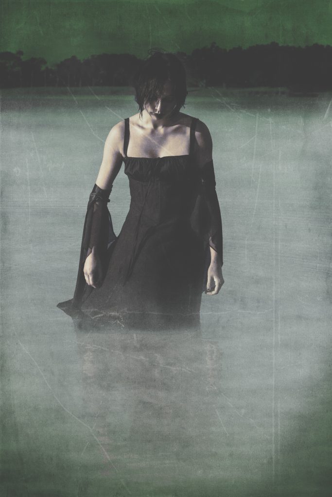 spooky girl coming out of a lake