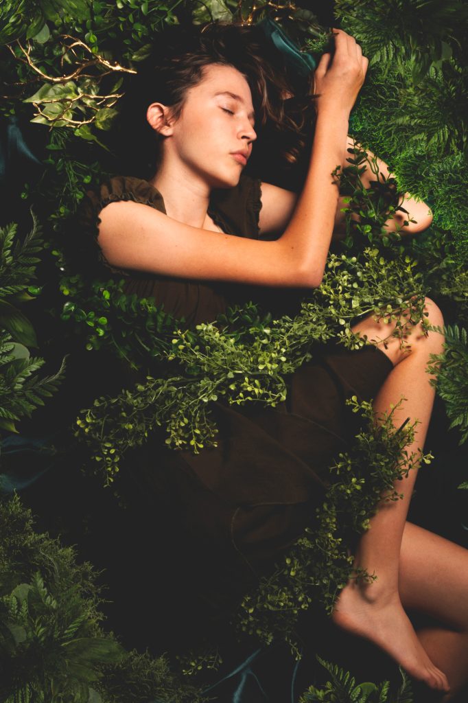 girl sleeping on forest floor