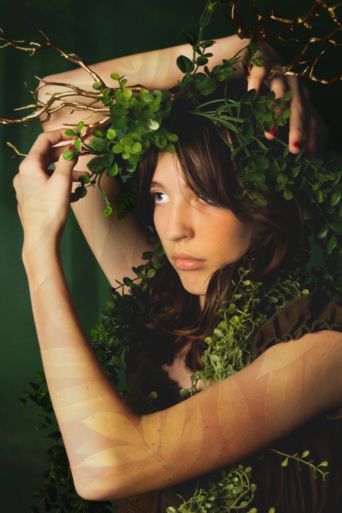 girl with antlers surrounded by forest