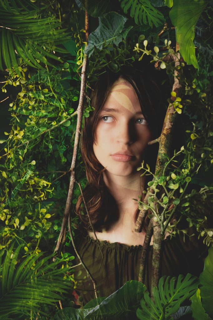girl with antlers surrounded by forest